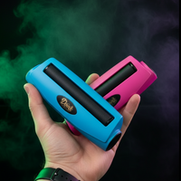 Hand holding two joint rollers by DoinkRollerz, one blue and one pink, against a dark background with smoke effects.